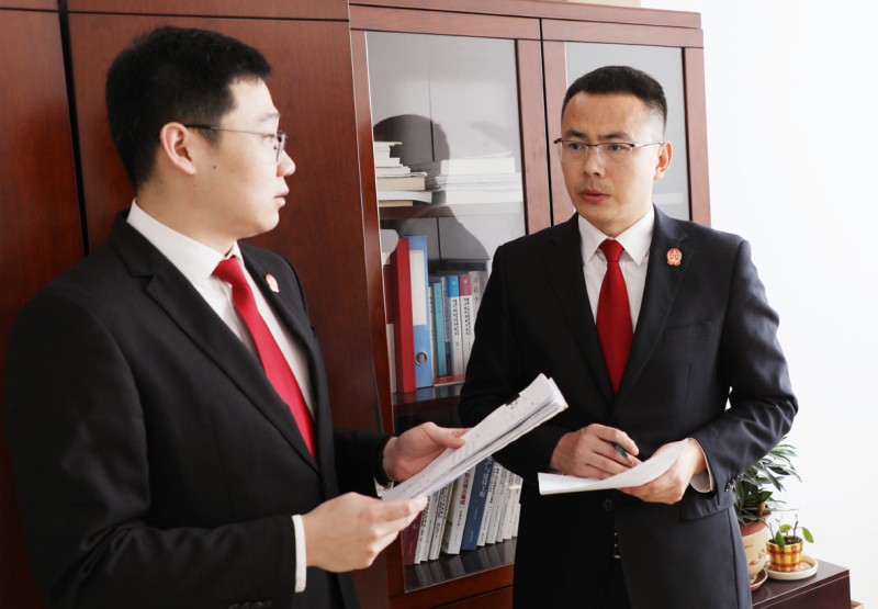 a鐵嶺市中級人民法院執行指揮中心主任應琦（右）與同事討論案件