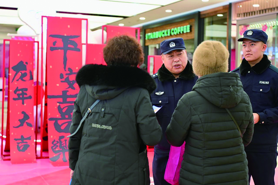 春節期間,民警老徐(左二)囑咐群眾要防范電信詐騙