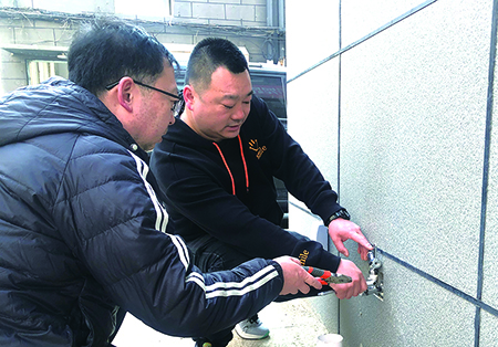 王闖(右)義務(wù)安裝水龍頭