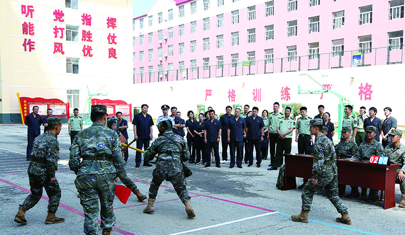 法院干警在訓(xùn)練場(chǎng)上觀(guān)看武警官兵軍事科目訓(xùn)練