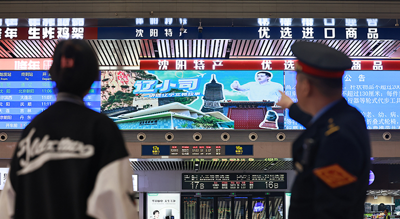 沈陽(yáng)站候車(chē)大廳，旅客和乘警一起觀看“遼小司”視頻。 本報(bào)記者 孟浩 攝