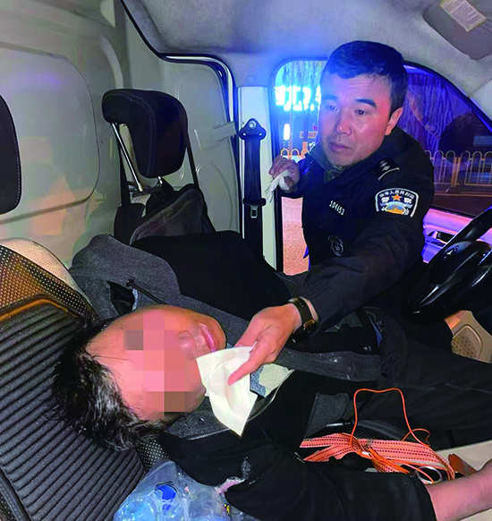 巡組民警趙正超為昏迷司機擦拭口鼻異物